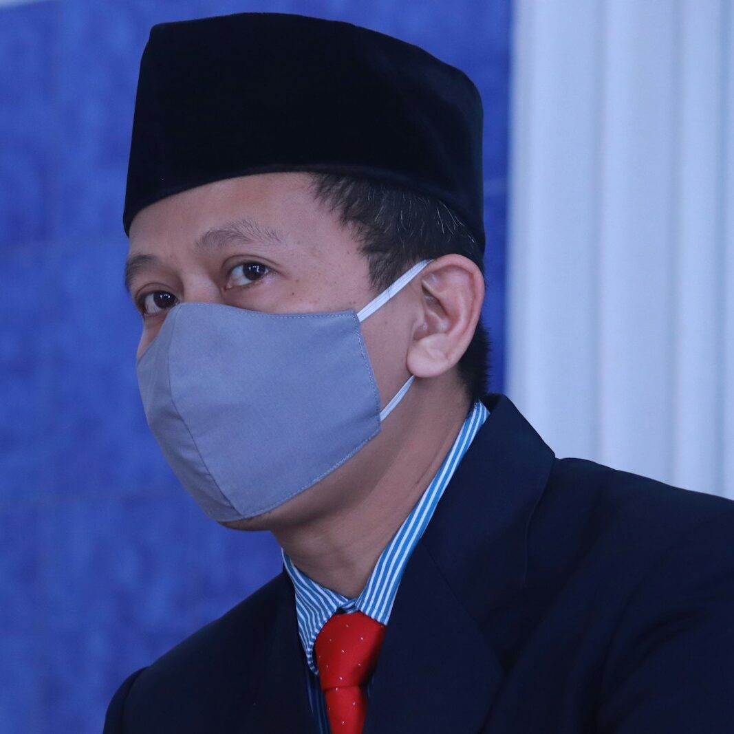 man in black suit wearing white face mask
